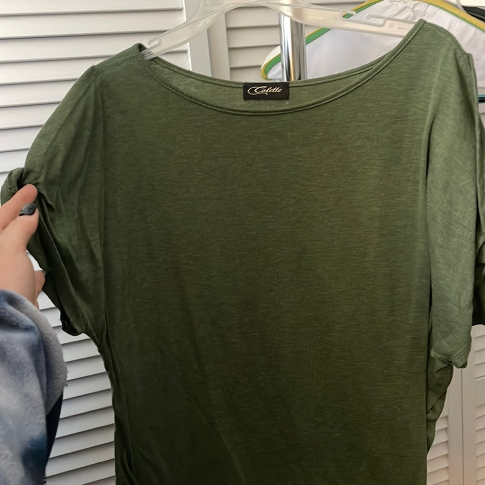Green T-shirt with holes on shoulders.